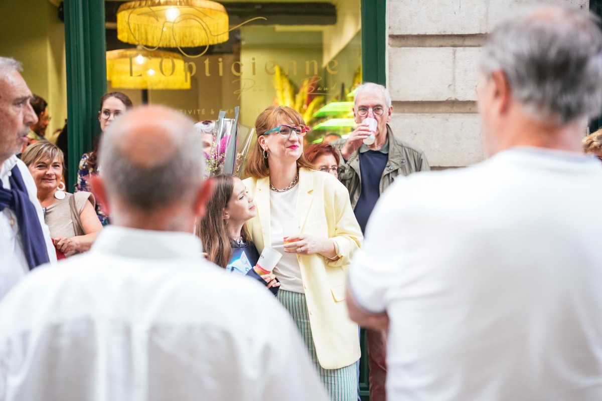Photographie d'une inauguration où l'on voit l'organisatrice regarder les chanteurs venus pour cette soirée